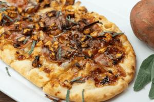 Eine lange Pizza, belegt mit herbstlichen Zutaten