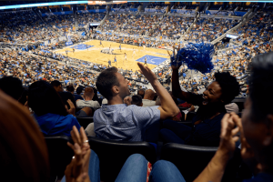 Two friends high-fiving while watching an Orlando Magic game
