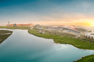 Large lake and on the other side you can see Ferrari World huge red building, Yas Waterworld, a large orange building and the outside of Yas Marina Circuit.