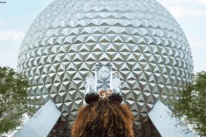 Mädchen mit Micky Ohren steht vor dem Spaceship Earth im Freizeitpark EPCOT in Orlando
