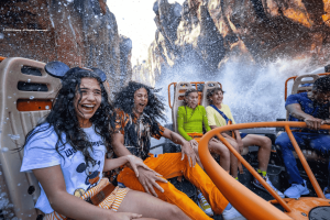 A group of friends getting splashed on a river raft ride