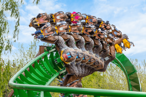 Monkey shaped rollercoaster cart twisting around a turn on the green rollercoaster track.