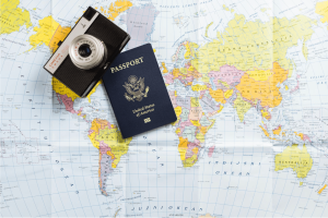 A US passport and camera resting on a world map, representing international travel, planning, and the major trends defining US travel in 2026.