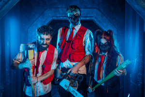 Three intimidating actors holding weapons in a blue-lit corridor