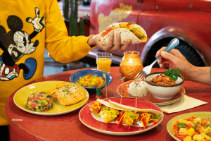 Table filled with colorful Mexican dishes including tacos, salmon, rice, and chili at La Cantina