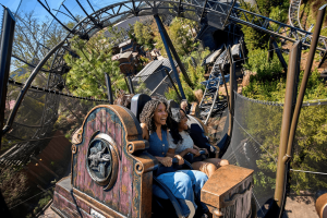 Two women smiling while riding the Curse of the Werewolf roller coaster