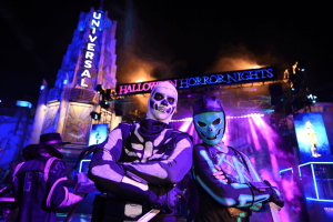 Two costumed Fortnite characters posing in front of an illuminated Halloween Horror Nights sign at Universal Studios