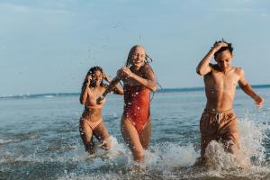 Three friends laughing and splashing in the sea on a summer holiday.