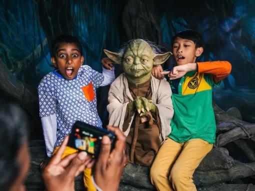2 boys having their photo taken with Yoda at Madame Tussauds London