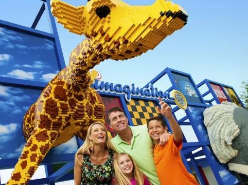 Family standing underneath a giant LEGO giraffe at LEGOLAND Dubai