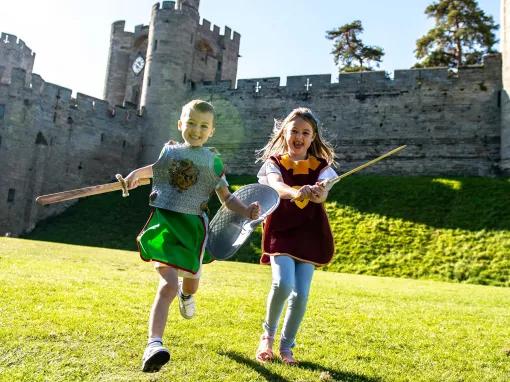 Boy and girl in medieval costume in front of Warwick Castle