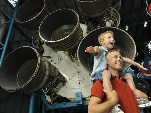 Father and son in front of the Apollo Saturn V Rocket at Kennedy Space Center