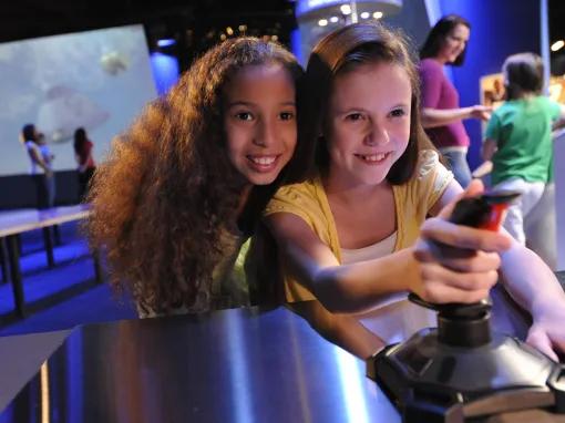 Girls playing with Exploration Space Simulators at Kennedy Space Center