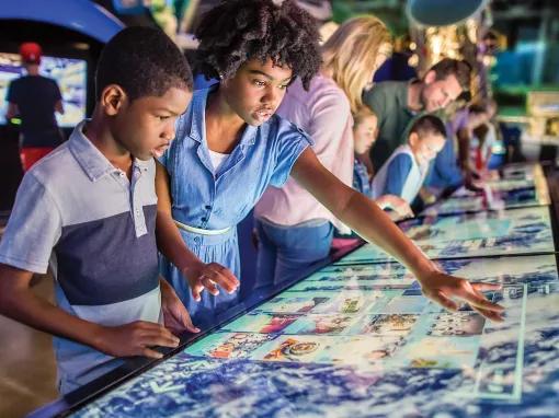 Boy and girl using Atlantis Touch Panels at Kennedy Space Center