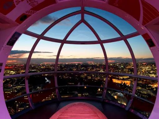 London skyline at night from the inside of a London Eye pod