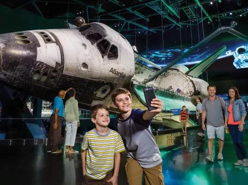 Boys taking a selfie in front of Space Shuttle Atlantis