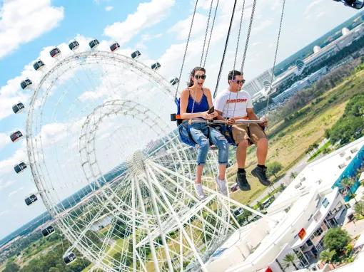 Two people riding the Starflyer at ICON Park