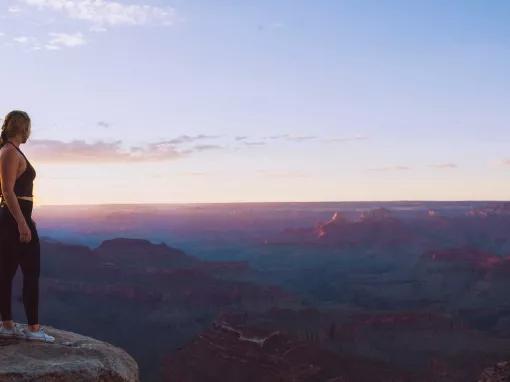 A person standing on the egde of the Grand Canyon on the The Grand Canyon Signature Sunset Tour