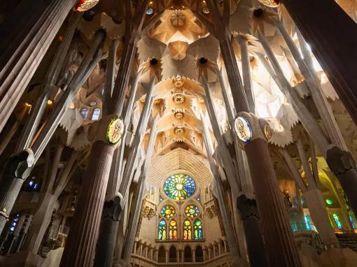 The inside of the Sagrada Familia, looking at a stained-glass window 