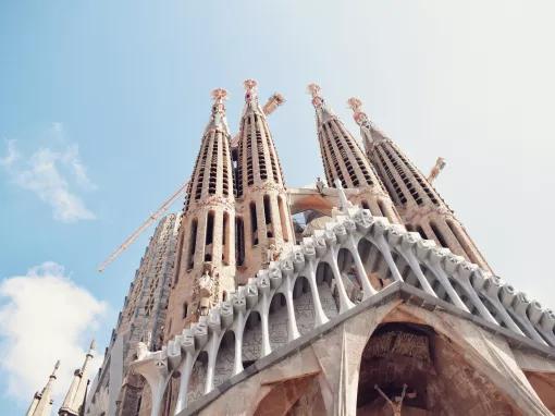 Looking up at the large towers of the Sagrada Familia in front of a blue sky