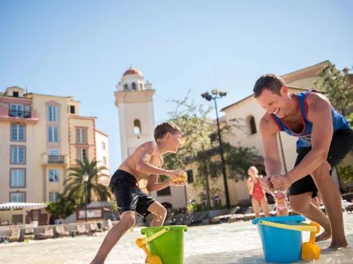 Father and son playing on the beach at Loews Portofino Bay Hotel