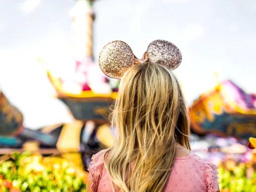 Girl with gold Disney ears in front of Magic Carpets of Aladdin, Walt Disney World