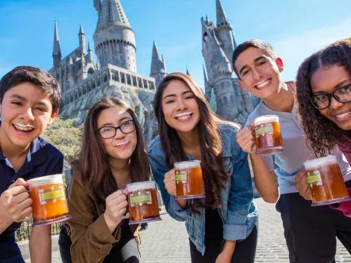 Guests enjoying butterbeer in front of Hogwarts castle at Universal Studios Hollywood