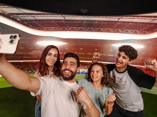 A happy family smiling while taking a selfie at the Bernabéu Experience in Real Madrid World Dubai