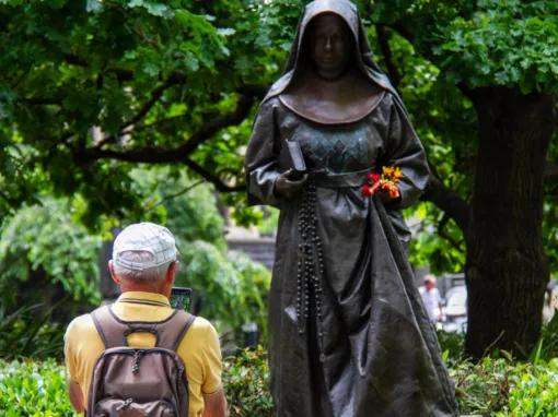 Person taking a photo of a statue outside St Patrick’s Cathedral during the Melbourne City Discovery Tour