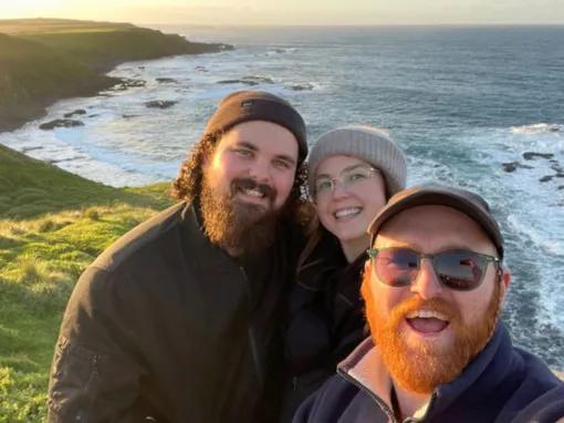 Tour guide with guests at the Nobbies lookout on Phillip Island, with ocean cliffs in the background