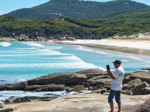 Person taking a photo from the Squeaky Beach lookout, capturing beautiful coastal views at Wilsons Promontory