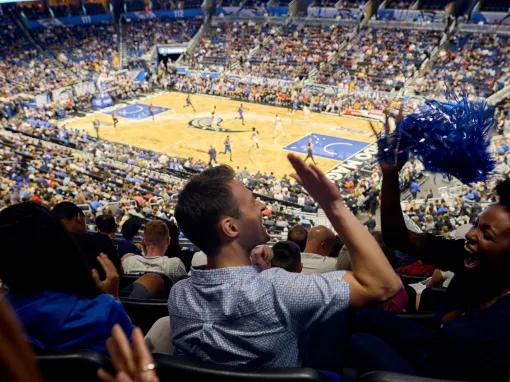 Close-up of two fans high-fiving and enjoying themselves in a lively, packed Orlando Magic stadium