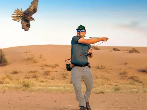 Man smiling with a falcon at Platinum Desert Safari Dubai