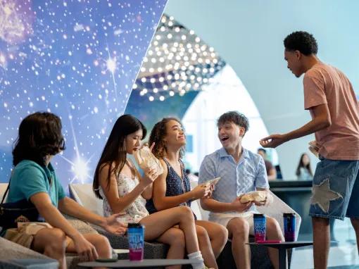 Guests eating pizza in the lobby at Universal Stella Nova Resort