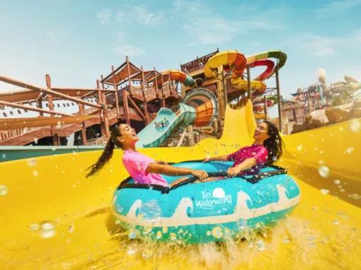 Friends laughing as they float down a tube slide at Yas Waterworld Abu Dhabi