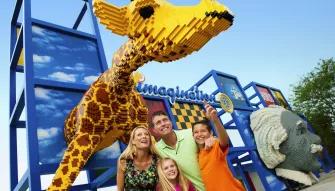 LEGOLAND Dubai Family standing underneath a giant LEGO giraffe at LEGOLAND Dubai
