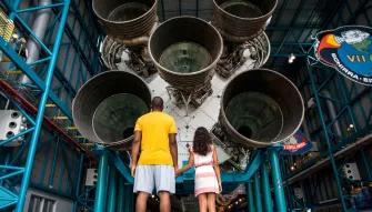 Father and daughter in front of Apollo Saturn V Rocket at Kennedy Space Center