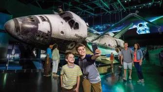 Boys taking a selfie in front of Space Shuttle Atlantis