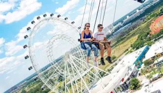 Two people riding the Starflyer at ICON Park