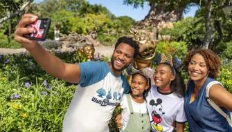 Family taking selfie in front of the tree of life at Animal Kingdom Theme park