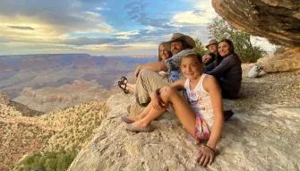 Grand Discovery Rim to Sky Tour People sitting on the edge of the Grand Canyon