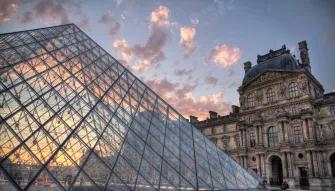 The Louvre Museum The glass pyramid of The Louvre museum in front of a sunset