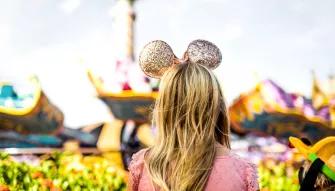 Girl with gold Disney ears in front of Magic Carpets of Aladdin, Walt Disney World