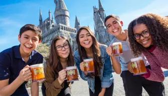 Guests enjoying butterbeer in front of Hogwarts castle at Universal Studios Hollywood