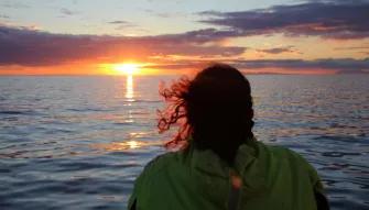 person-looking-out-to-sunset