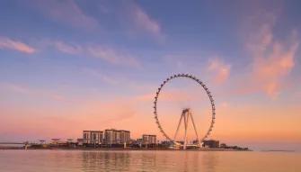 Ain Dubai silhouette at sunset, with vibrant sky and the observation wheel in the distance