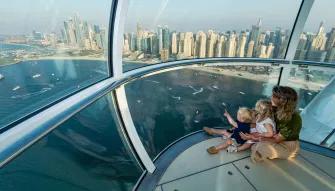 A mother and two young children enjoying the panoramic views of Dubai from a capsule on Ain Dubai.