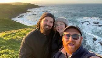 Tour guide with guests at the Nobbies lookout on Phillip Island, with ocean cliffs in the background