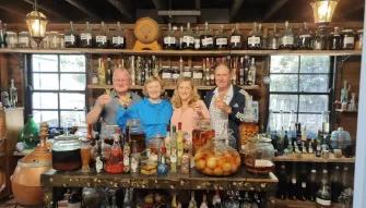 Explore Tamborine Tour Four people behind a bar smiling during a winery visit on the Explore Tamborine Tour