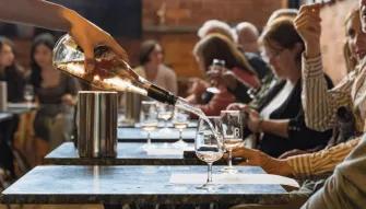 People seated at tables at Rochford Wines as wine is poured into a glass